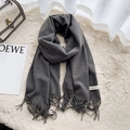 Sciarpa grigio scuro in finto cashmere con nappe su un tappeto di peluche - Grigio Melange Scuro