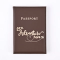Close-up of dark brown PU leather passport holder with golden adventure-themed engraving - Coffee