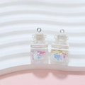 Macro shot of mini drifting bottle charms with colorful star sequins and liquid filling - White Wish Bottle