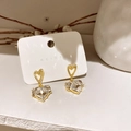 Detail of heart-shaped gold plated earrings with faceted zircon on display card - Gold Zircon Heart Pendant Style (66#)
