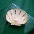 Elegante broche de concha con acabado dorado, perla central y cristales finos - Borde Dorado Concha Perla