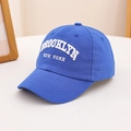Close-up of white Brooklyn New York 3D embroidery on a navy blue cotton baseball cap - Blue