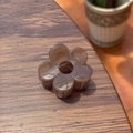 Vue détaillée de la pince à cheveux fleur ambrée avec texture sur bois sombre - 5cm / Marron Transparent