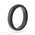 Detailed view of the black titanium steel bangle featuring a ribbed tubular texture - Black