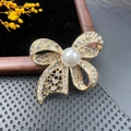Élégante broche nœud dorée sertie de cristaux avec une grande perle blanche - BZ091 Nœud de Perles