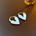 Detailed close-up of gold heart earrings with white enamel on a leather background - 5# White Heart Enamel Ear Clip