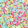 Macro detail of mixed macaron color resin bow and star charms for nail art and crafts - Cherry