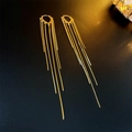 Macro detail of gold-plated heart tassel earrings on black textured backdrop - Gold Tassel Ear Clips