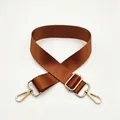 Close-up of brown nylon shoulder strap with golden metal swivel hooks and adjuster - Brown