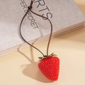 Dettaglio di un ciondolo a fragola in resina rossa con collana in cordoncino di cuoio marrone - Stile Fragola Rossa Grande