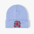 Detail of light blue knit beanie with black embroidered text and red lip prints - Sky Blue
