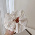 Macro detail of creamy white lace scrunchie with floral embroidery and soft texture - Hair Tie