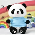 Schattige panda knuffel met blauwe trui zittend bij kleurrijke decoraties - Panda met meerblauw T-shirt