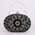 Detail of black rhinestone evening clutch with gold metal flower and gemstone inlay - Black