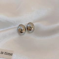 Orecchini a perno ovali in argento lucido presentati su elegante seta bianca - Argento