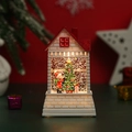 Macro shot of illuminated Christmas snow house featuring Santa and interior glitter decor - Boy and Christmas Tree