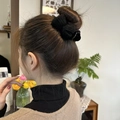 Elegant black knit bow claw clip for buns, showing hairstyling on a female model - Black