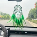 Green crystal dreamcatcher car charm with feathers hanging from a rearview mirror - Green