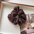Detailed view of a dark brown satin scrunchie with soft sheen and elegant pleated texture - Medium / Dark Coffee