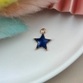 Primer plano macro de un colgante de estrella en esmalte azul dorado con ojal superior - Estrella
