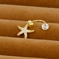 Vue macro d'un piercing nombril étoile de mer dorée avec zircone sur présentoir - Style Design Étoile de Mer (Y20370-6)