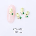 Macro shot of 6x11mm green tulip nail charms with gold edges on a pink nail tip - Green Tulip Gold Base (8511)