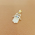 Goldener Hamsa-Hand-Anhänger mit blauem Stein und Zirkonia auf Lederhintergrund - 1-Gold Hamsa Hand Blaues Auge