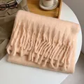Écharpe en mohair rose pêche avec franges, disposée sur table pour l'hiver - Rose racine de lotus