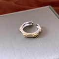 Macro-opname van vintage ovale open ring met groene stenen en goudkleurige details - Vintage Ovale Open Stijl / Tweekleurig Goud Zilver (Groene Edelsteen)