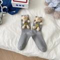 Cute 3D plush bear socks in grey with a yellow smiley face patch on white bedding - One Size / Gray