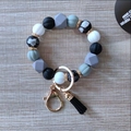 Detail of silicone beaded keychain with black leather tassel and gold lobster clasp - Black