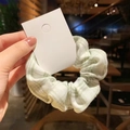 Light green and white plaid scrunchie with fluffy texture on a white hanging card - Artistic Girl Green White Grid