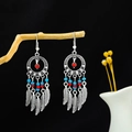 Detailed shot of bohemian silver dreamcatcher earrings with turquoise beads and feathers - Multicolor (Dreamcatcher)