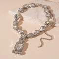 Collana di lusso argentata con cristalli a goccia e quadrati su superficie in pietra - Collana con Goccia d'Acqua in Strass Argento