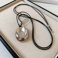 Détail d'un pendentif géométrique en argent poli sur cordon noir en boîte bijou - Pendentif Argenté Avec Corde Noire