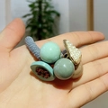Dettaglio di elastico blu con perline verdi Morandi e ciondolo in perla dorata chic - Set di Elastici Intrecciati / Azzurro