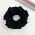 Detailed top view of a black pleated faux leather oversized scrunchie on a white surface - Black (Three-layer)