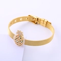 Detalle de una pulsera de malla dorada con un dije de piña con circonitas de colores - Dorado