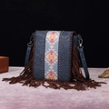 Macro detail of embossed blue leather crossbody bag with ethnic fringe and silver rivets - Blue