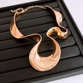 Detail der roségoldenen Wellen-Halskette mit polierter Metallstruktur und Karabinerverschluss - Gold