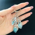 Close-up of translucent seashell resin charms filled with blue glitter and pearls - Lake Blue