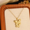 Golden double butterfly pendant necklace with elegant chain shown on a display tray - Gold Double Overlapping Butterfly Pendant Necklace