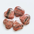 Red and black striped natural heart stones arranged in a floral pattern on white background - Marble Red Stone