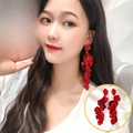 Detail of long red petal tassel earrings with gold ring connectors on female model - Rose Petal Tassel Stud Earrings