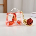 Dettaglio di un portachiavi a borsa trasparente con sabbia mobile rossa e bambola - Capybara Sabbie Mobili / Mini Borsa