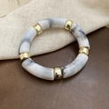 Dettaglio di perle in acrilico marmorizzato con distanziatori dorati su base in pelle - Bianco Grigio (Motivo Marmo)