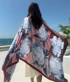 Detail of ethnic floral print sun protection shawl showing silk texture against sea background - Pink Base Large Floral (Daisy-2)
