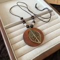 Collana con pendente tondo in legno e foglia metallica su cordino marrone scuro - 4# Collana-Caffè (Foglia Traforata)