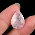 Pink quartz teardrop faceted pendant held between fingers showing size and texture - Rose Quartz