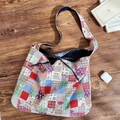 Detail der mehrfarbigen Patchwork-Schultertasche mit Kordelzug und blauem Jeansriemen - Blumen-Gitter-Patchwork